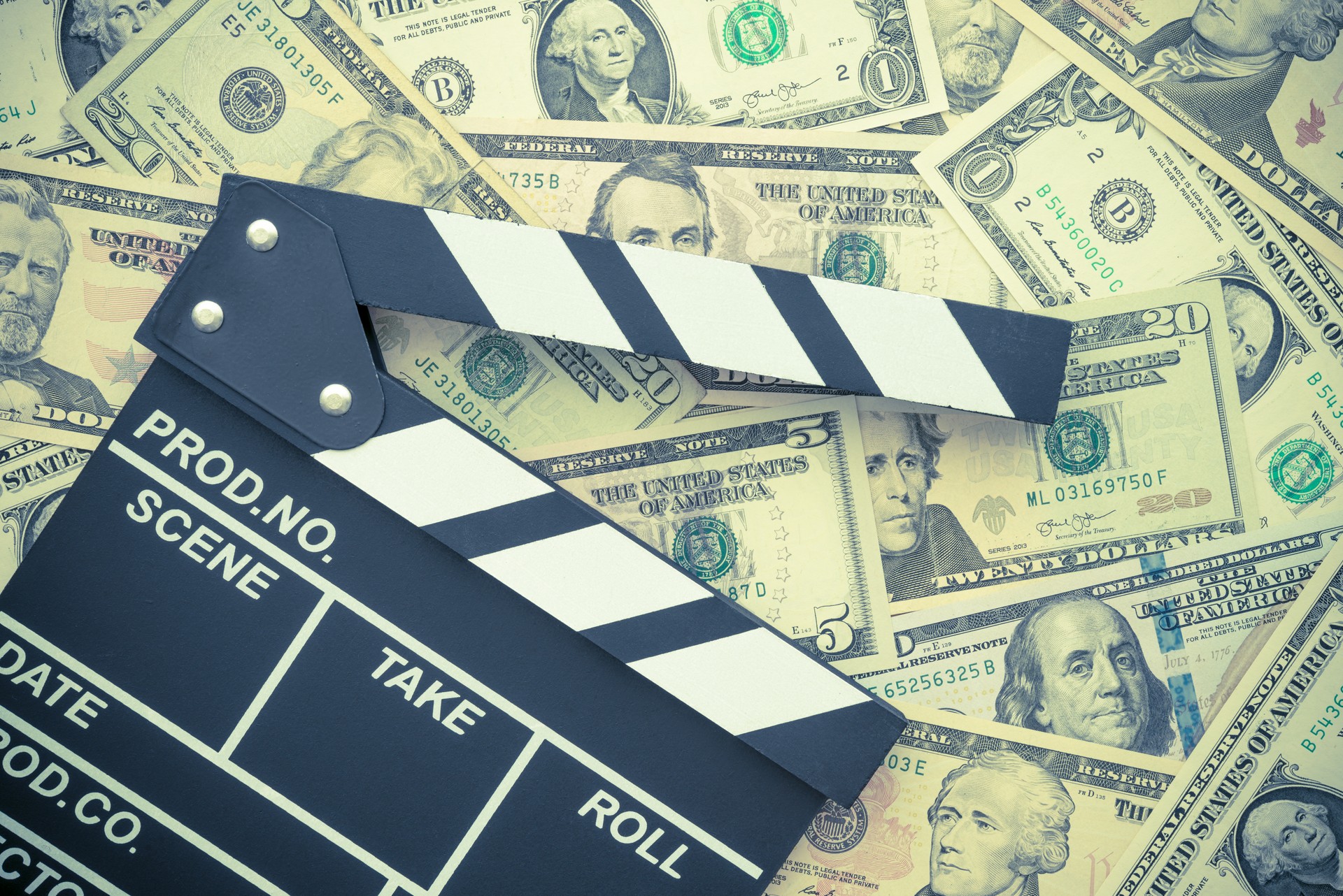 Cinema clapperboard on US dollars banknote bill background.